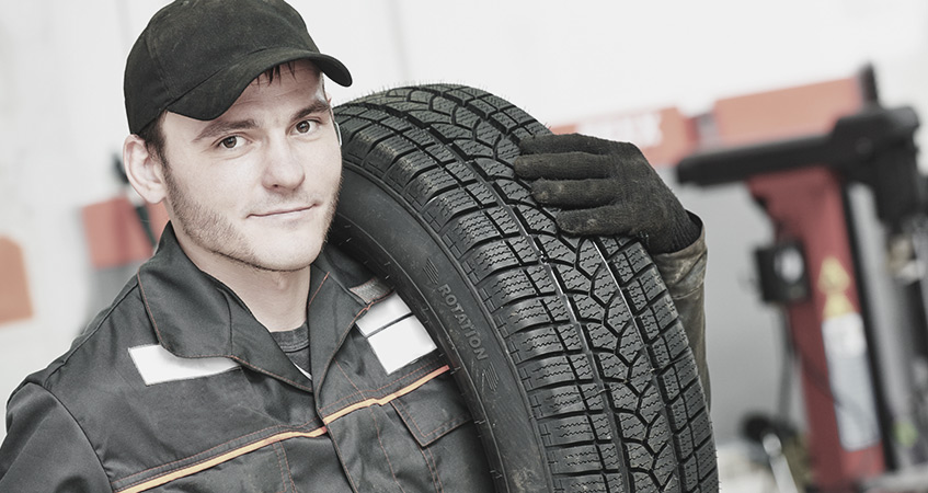 Tyre technician carrying car tyres for fitting - Tyres Nottingham